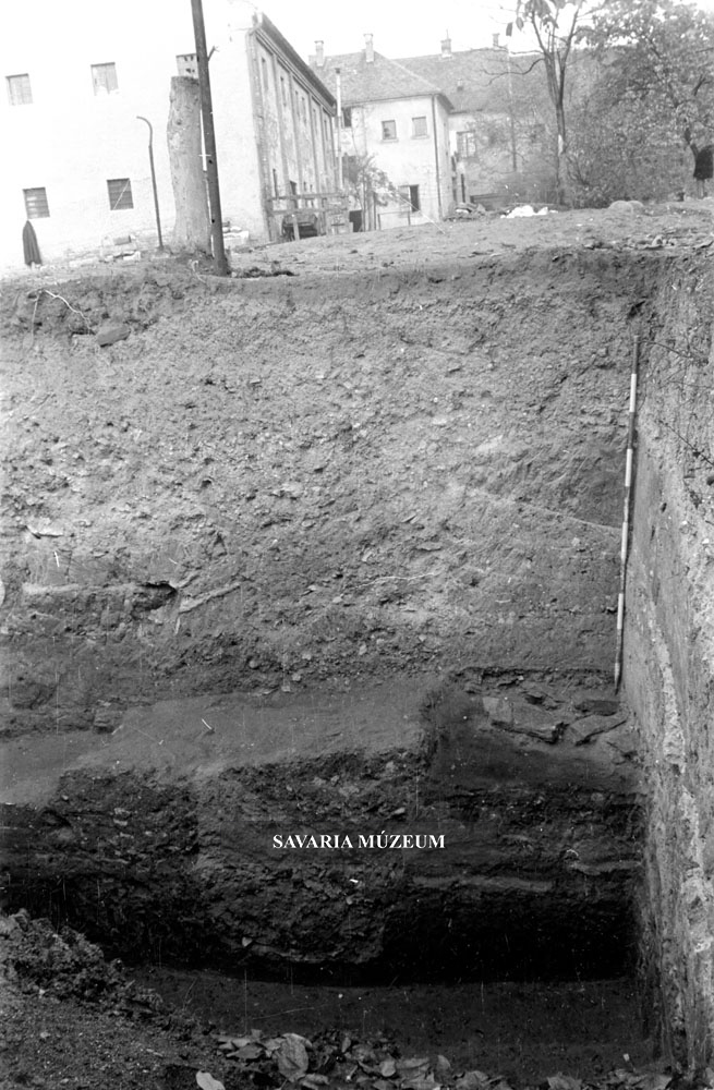 Római fal törmelékkel feltöltött alapárkának alja és a modern talajszint viszonya, délről fotózva. Isis-szentély, Szombathely